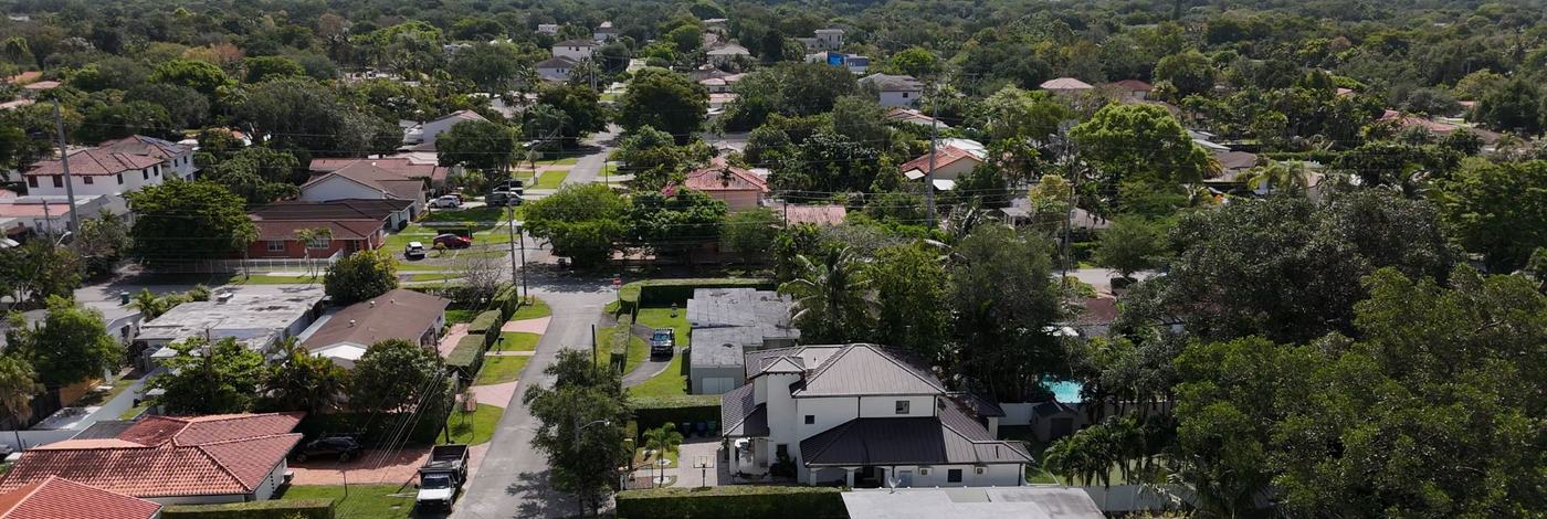 Aerial view of Schenley Park streets toward the Miami skyline — lots and housing stock in ZIP 33155